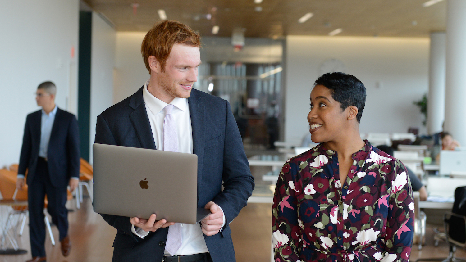 man and woman walking with laptop